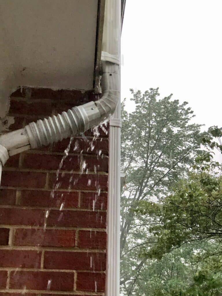Rain overflowing gutters and downspout
